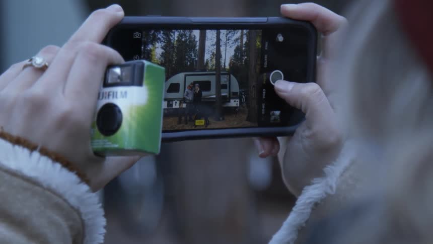 A person is taking a photo of their camper with a cellphone