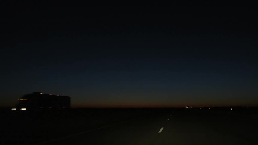 Driving down a street after sunset
