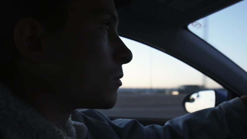A man is driving a car on the highway