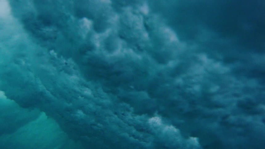 Waves crash into the ocean creating bubbles below