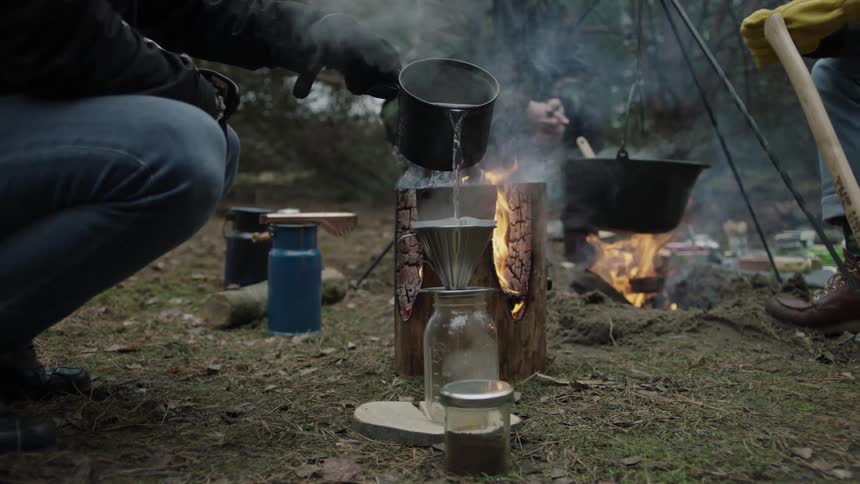 A person pours boiling water into a jar