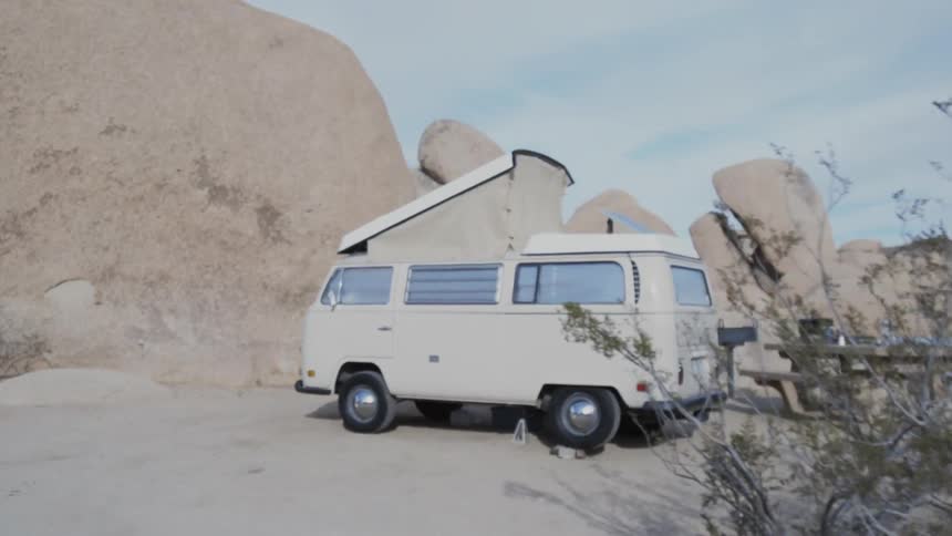 A popup van is set up at a campsite