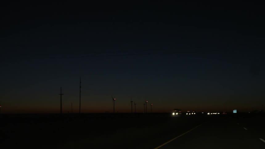 Cars drive on a highway at dusk