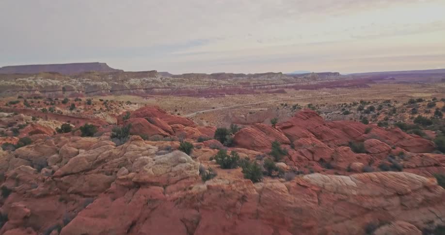 Shrubs and clay formations cover the top of a mountain