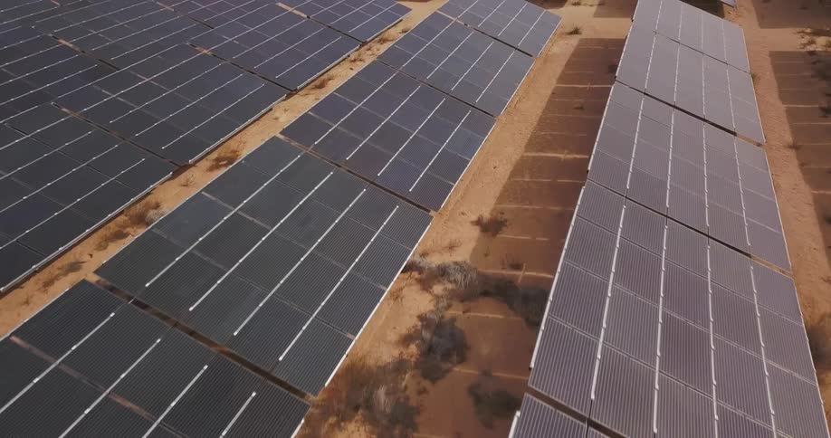 Solar panels aimed towards the sun in a large field