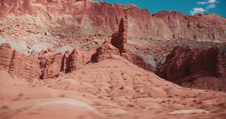 Mountains and sand sit  under a blue sky