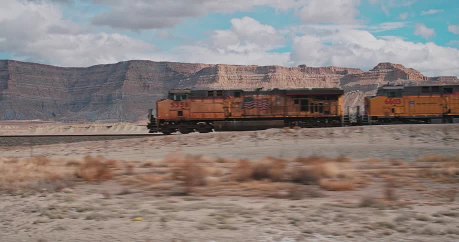 A train travels through a desert landscape