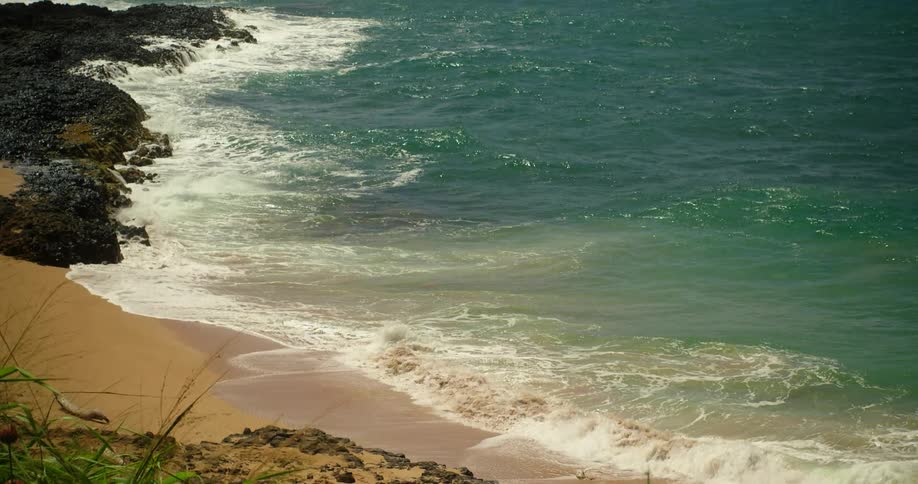 Waves lap a rocky beach on a sunny day