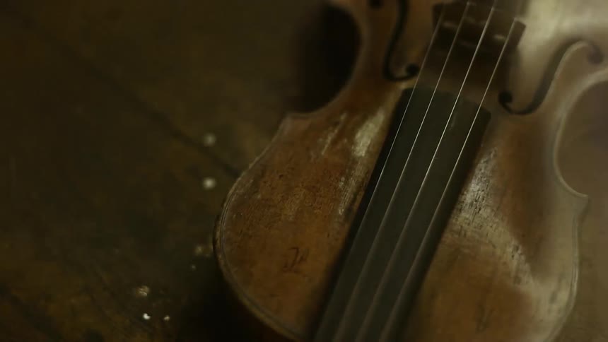 A violin sits on a wooden table