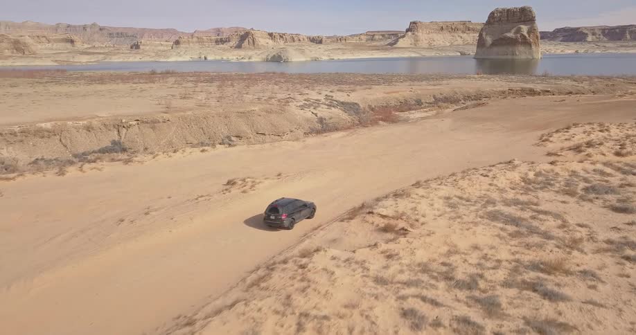 A truck drives towards a lake
