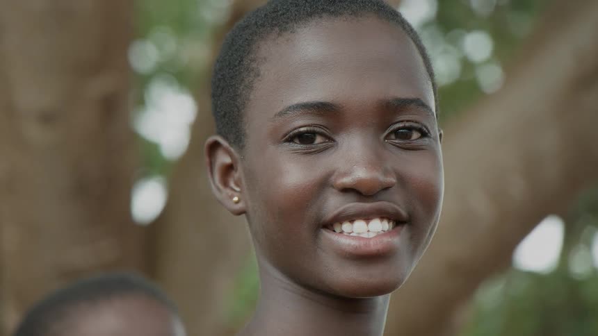 Young woman wearing stud earrings smiles brightly