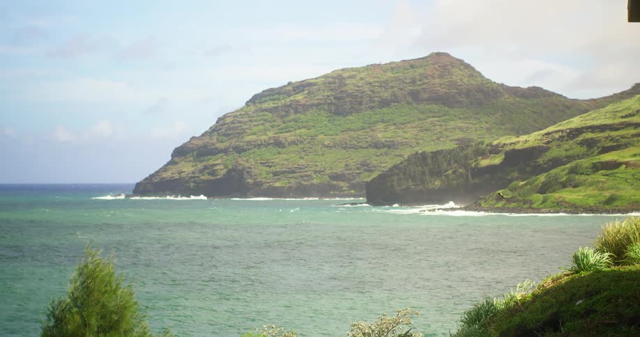 A green rocky hill overlooking the ocean