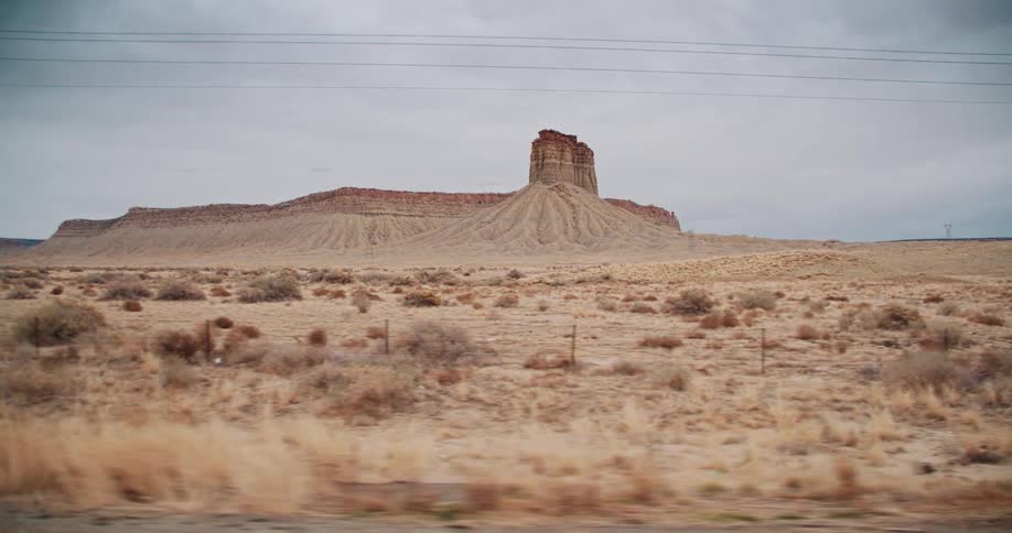 Large sand dune sits in the desert under a cloudy sky