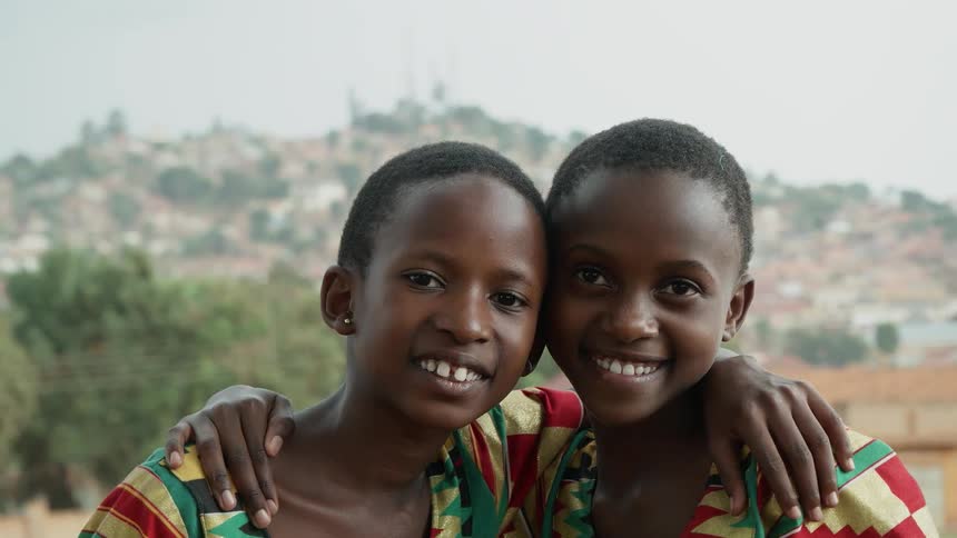 Two young women stand each with an arm around the other