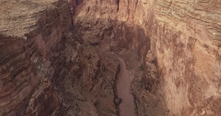 A river trickles through a desert canyon gorge