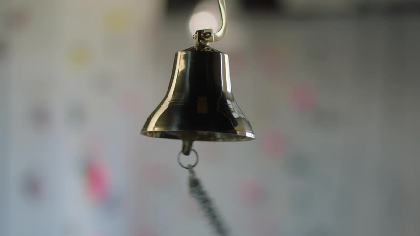 Someone rattles a chain hanging from a silver bell