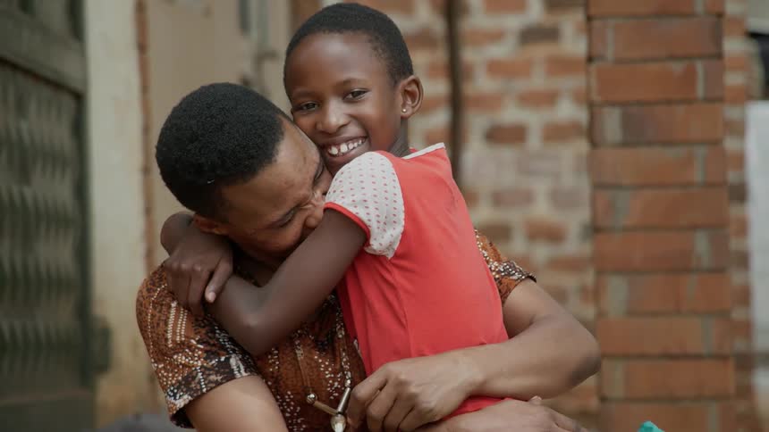 A woman hugs a young child