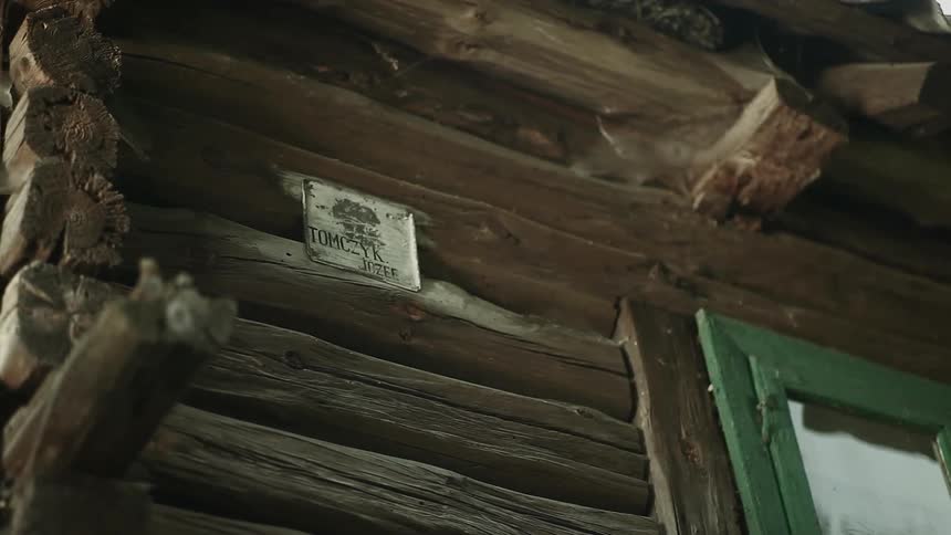 A sign on an inside wall of a log cabin