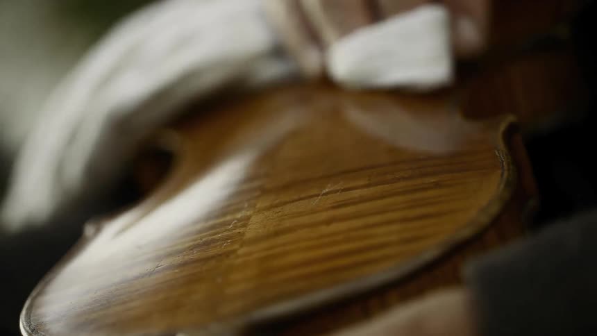 A person polishing a violin