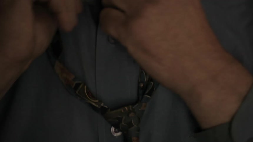 A man fixes a necktie around his neck