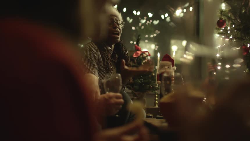 Group of people listening to a woman in a santa hat talk