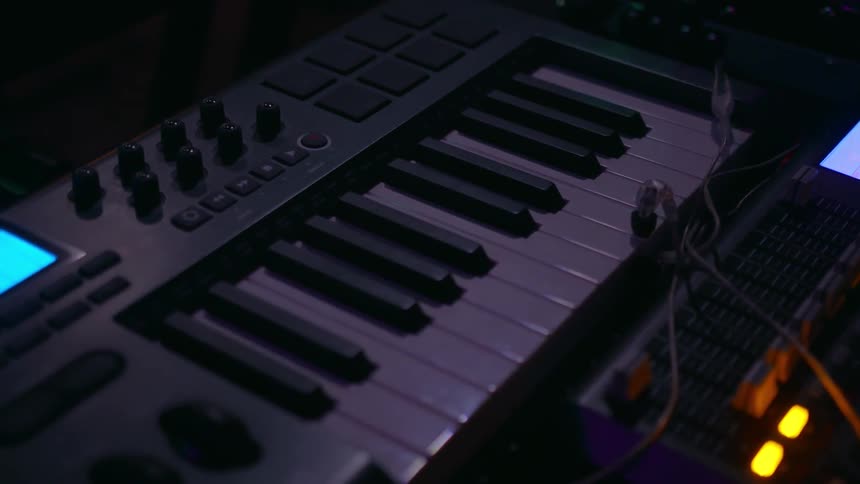 Lights on keyboards and audio mixers light up the room