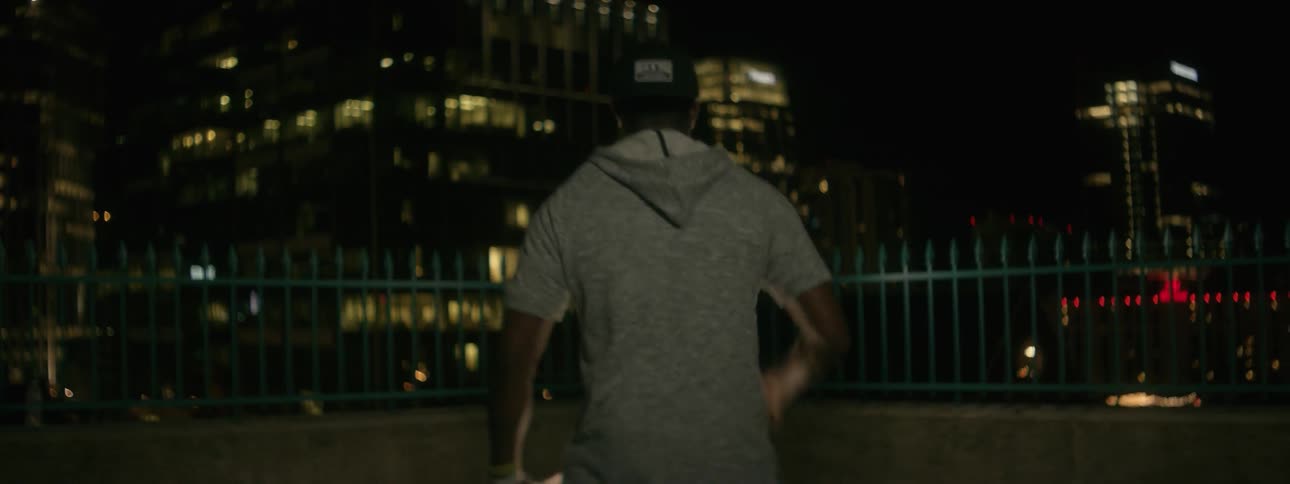 Man plays a drum in a city at night