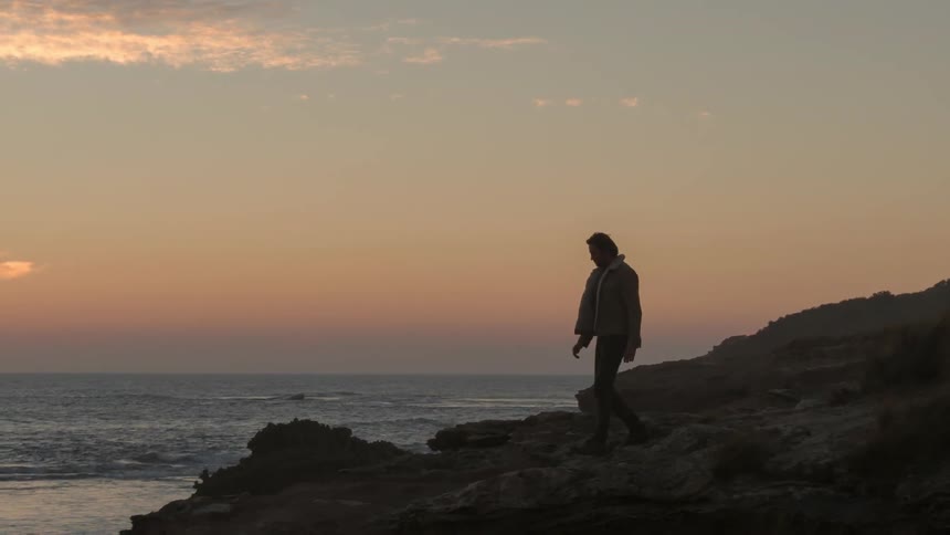 A man walks towards the beach shore
