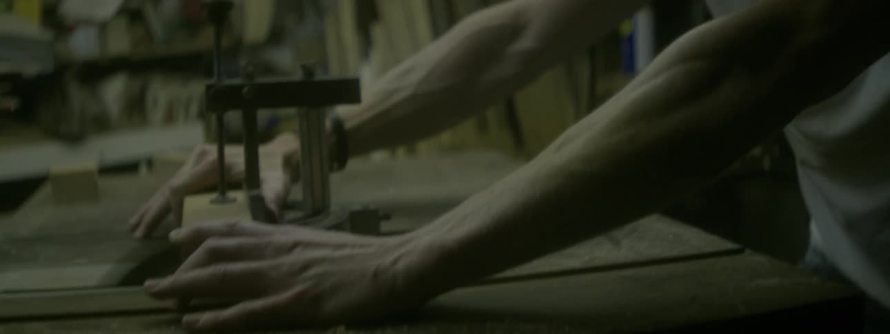 A man cuts a piece of wood with a table saw
