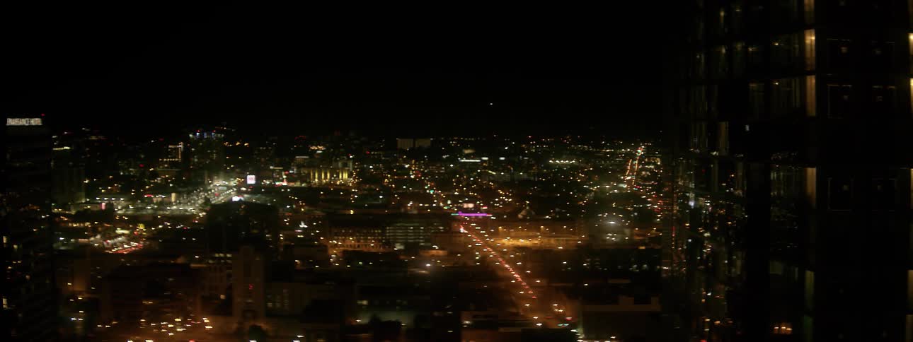 City building and vehicle lights illuminate the night sky