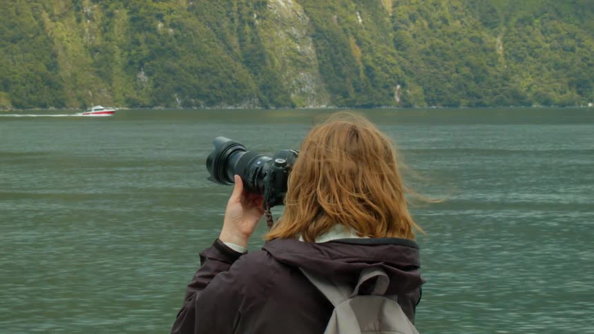 A photographer takes photos while riding on a boat