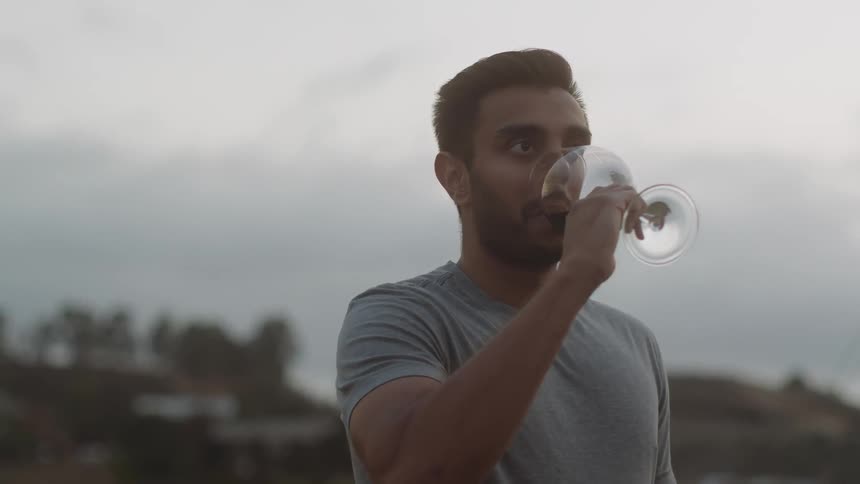 Man drinks wine while outside
