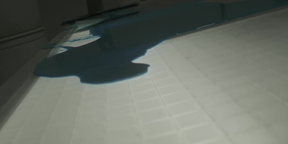 A blue liquid spreads out on a lighted table