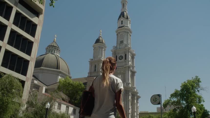 A woman walks outside near a church building