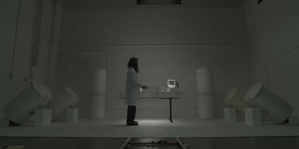 Man in lab coat swings a hammer