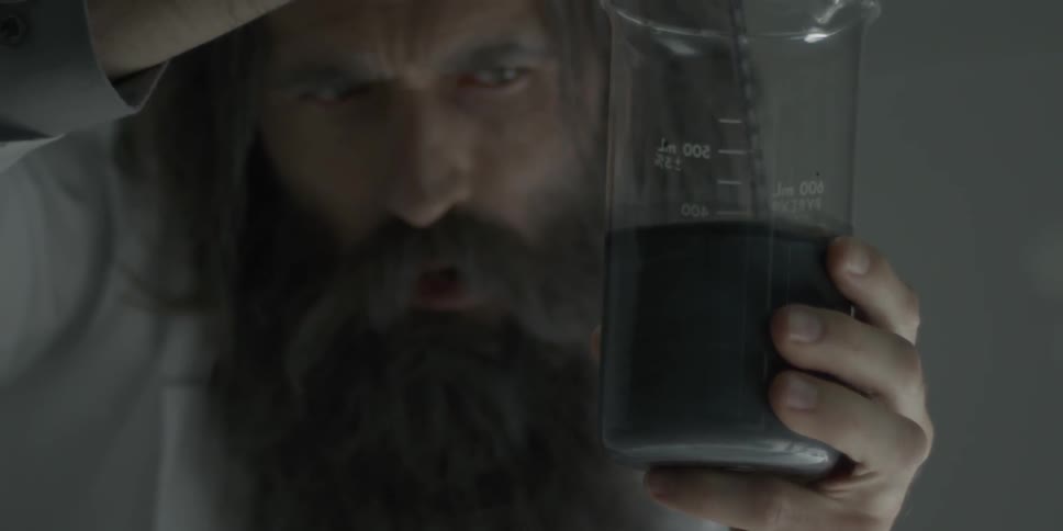 A man examines liquid in a beaker