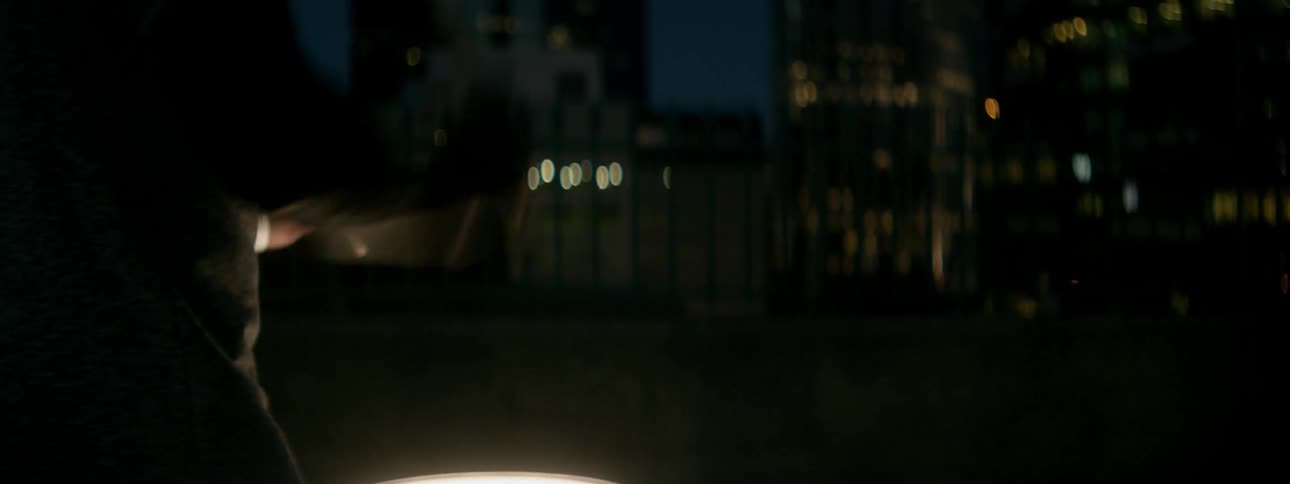 Man plays drums in a city at night