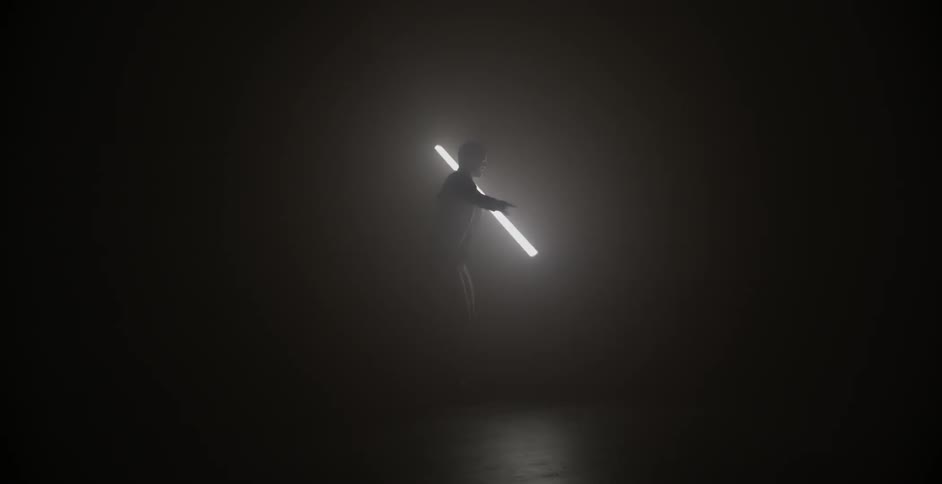 A man holding a fluorescent light stick is dancing in the dark