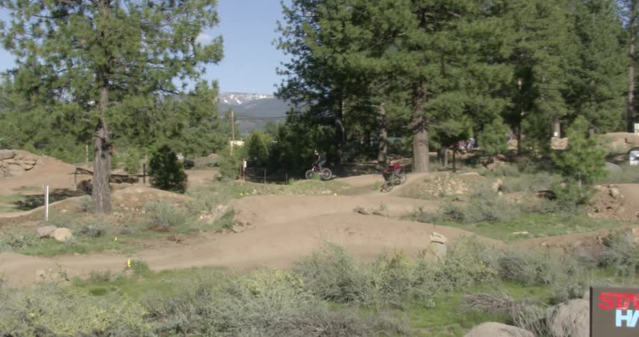 Boys race off road bikes on a course in a natural setting