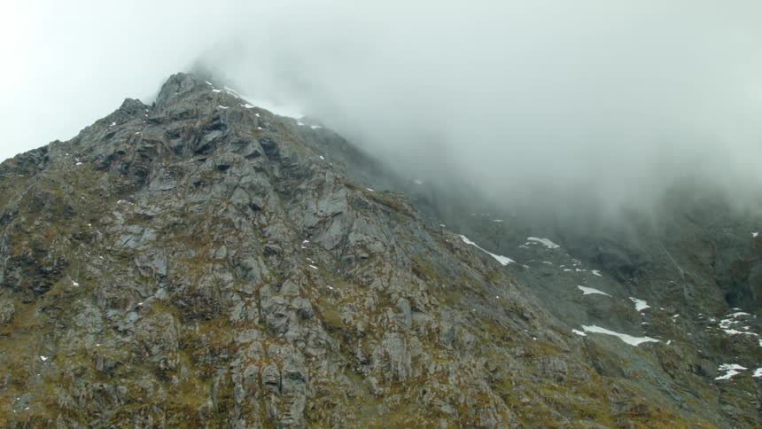 Fog hangs above a rock mountain