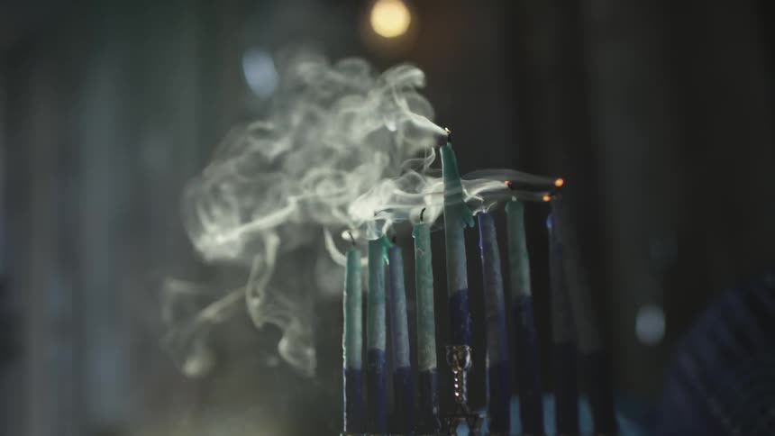 Someone blowing out a menorah