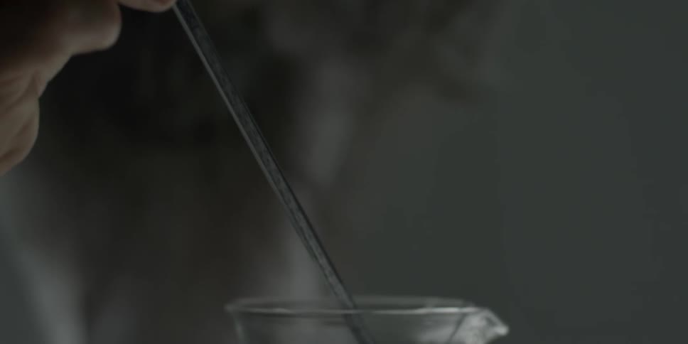 Man stirs substance in a beaker