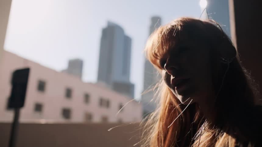 A red haired woman's hair blows in the breeze