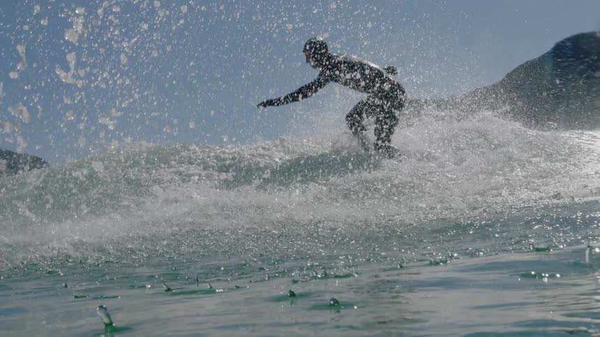 Water splashes around a surfer riding a wave