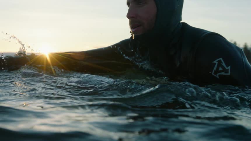 Man in a wetsuit swims in the water