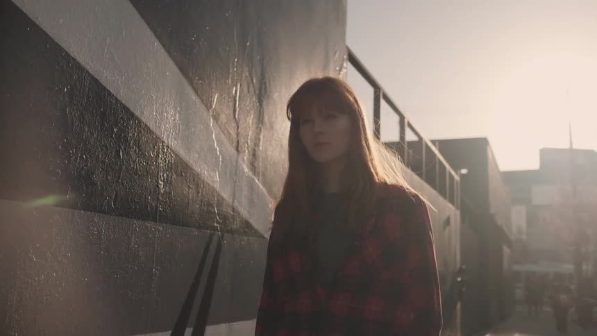 A red haired woman walks outside in the city