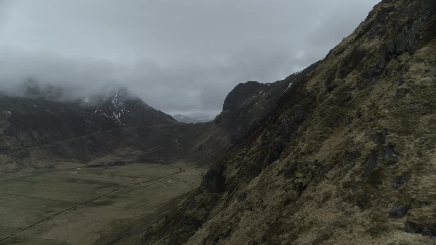 Clouds drift between mountain peaks surrounding a valley