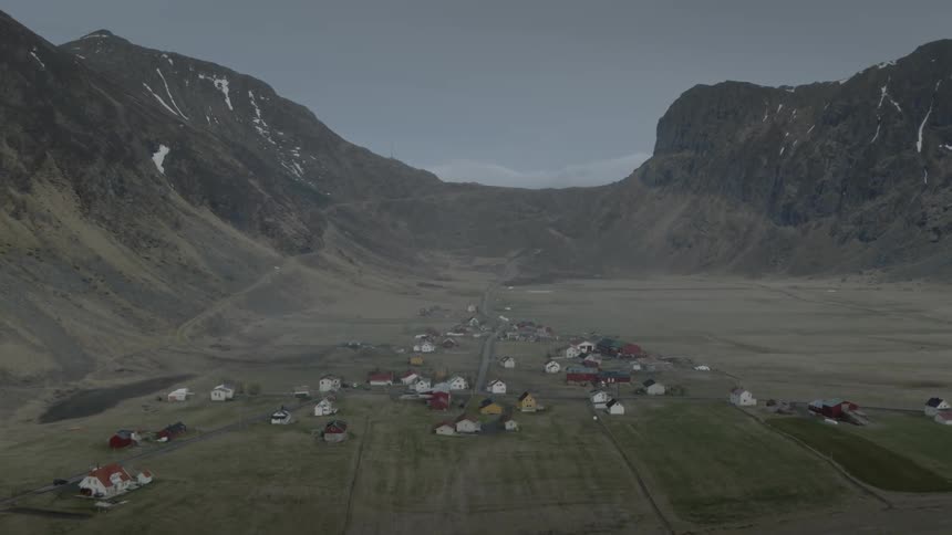 Houses sparsely cover the land between mountains