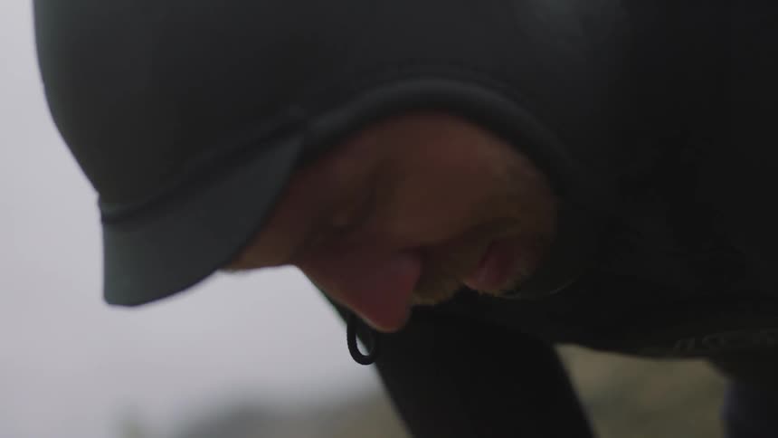 A man in a wet suit leans over