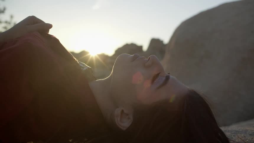 A woman lays outside in the sun